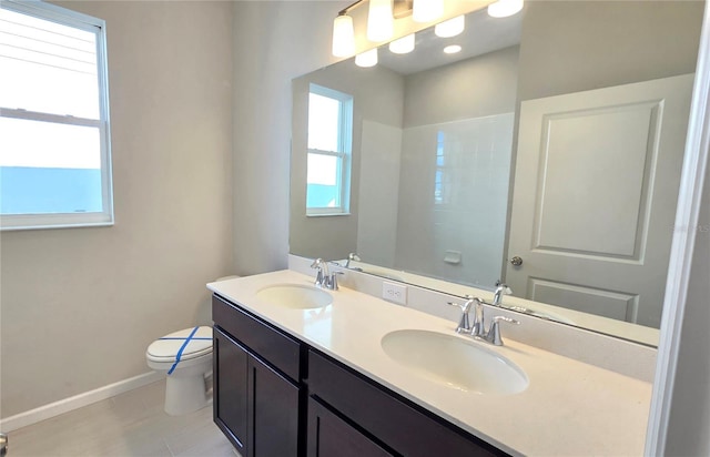 bathroom featuring plenty of natural light, vanity, and toilet