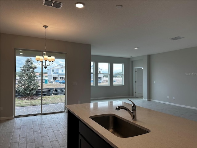 kitchen featuring sink, hanging light fixtures, and a chandelier