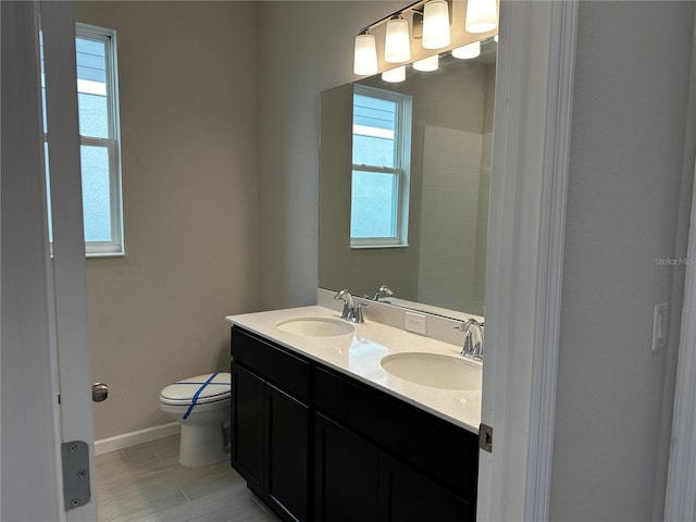 bathroom with plenty of natural light, vanity, and toilet