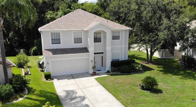 view of front of home with a garage, a shingled roof, concrete driveway, stucco siding, and a front yard