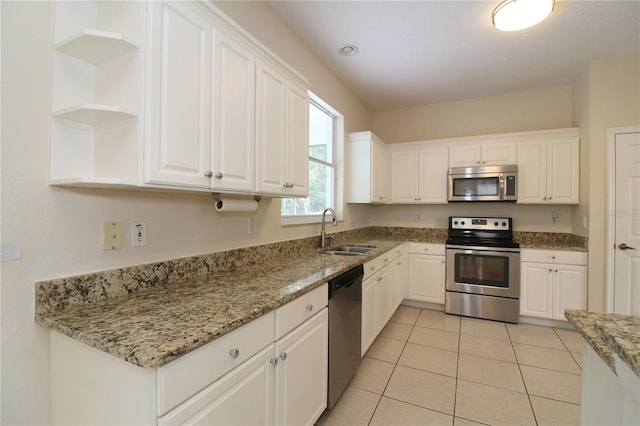 kitchen featuring light tile patterned floors, white cabinets, stainless steel appliances, open shelves, and a sink