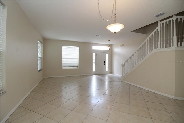 entryway featuring light tile patterned floors, baseboards, stairs, and visible vents