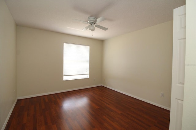 spare room featuring wood finished floors, a ceiling fan, and baseboards