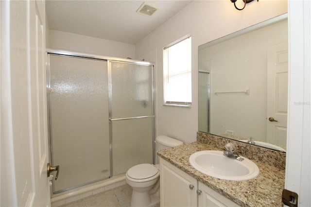 bathroom featuring tile patterned flooring, vanity, toilet, and a shower with shower door