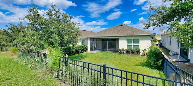 rear view of property with a yard and a sunroom