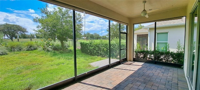 unfurnished sunroom featuring ceiling fan