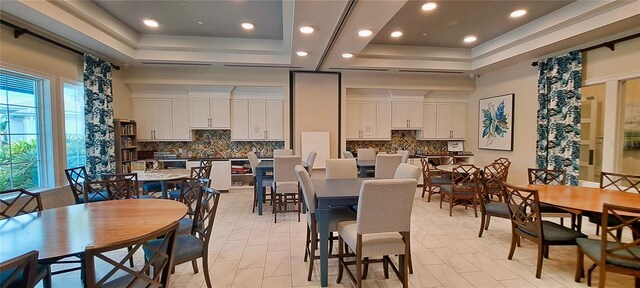 dining room featuring plenty of natural light and a raised ceiling