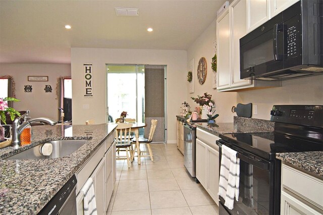 kitchen featuring stone counters, black appliances, sink, and white cabinetry