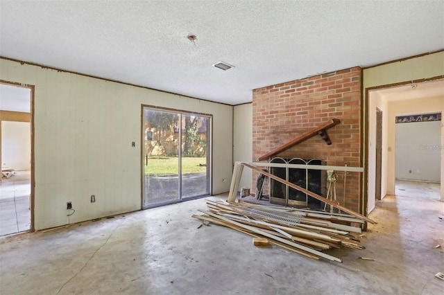 unfurnished living room featuring a textured ceiling and concrete floors