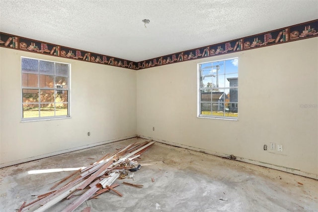 unfurnished room featuring a wealth of natural light and a textured ceiling