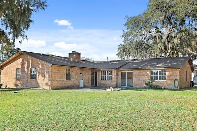 rear view of property with a lawn and a patio area