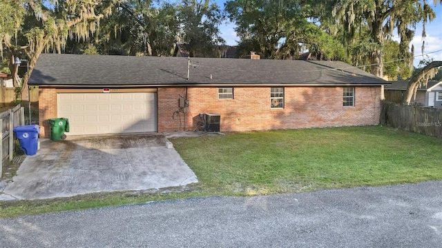 single story home with central AC unit, a front yard, and a garage