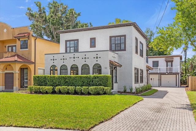 mediterranean / spanish home featuring a front lawn, a garage, and a balcony