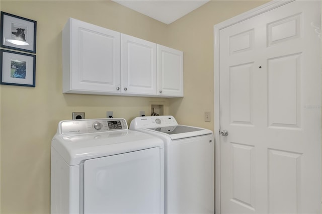 laundry room featuring washing machine and dryer and cabinets