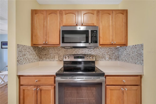 kitchen featuring appliances with stainless steel finishes and tasteful backsplash