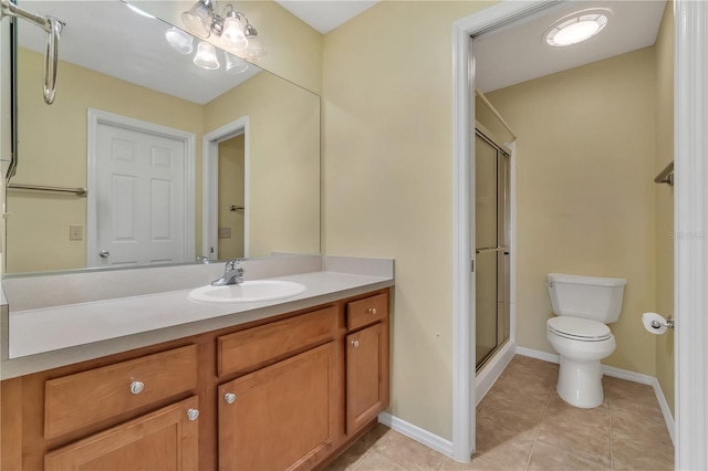 bathroom with a shower with door, toilet, vanity, and tile patterned floors