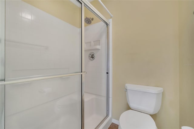 bathroom featuring an enclosed shower and toilet