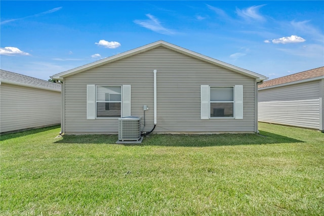 back of house featuring a lawn and central AC unit