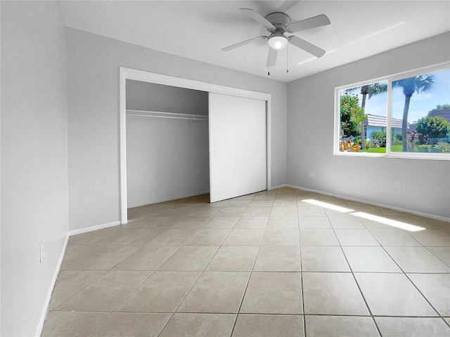 unfurnished bedroom with ceiling fan, light tile patterned floors, and a closet