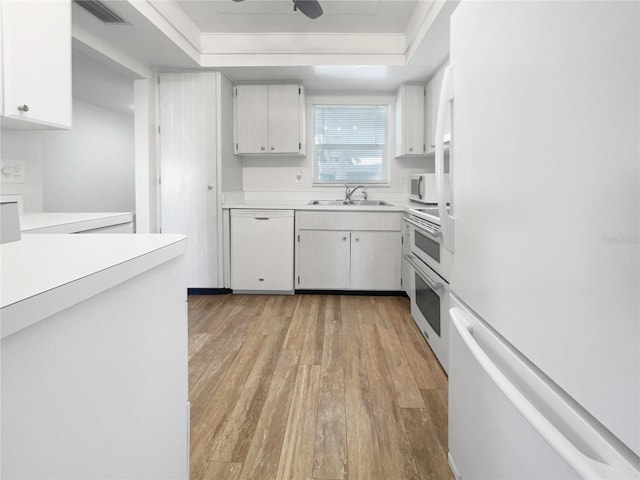 kitchen with sink, light wood-type flooring, white cabinets, white appliances, and ceiling fan