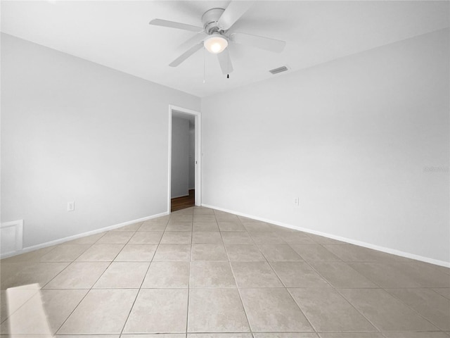 spare room featuring visible vents, ceiling fan, baseboards, and light tile patterned floors