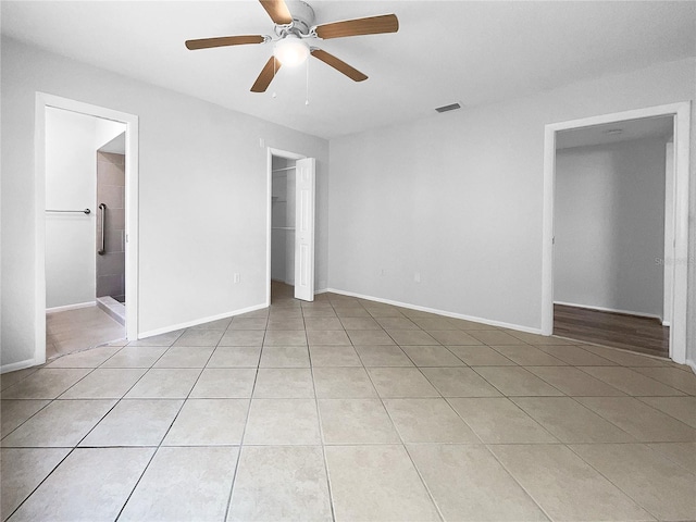 spare room featuring ceiling fan and light tile patterned floors