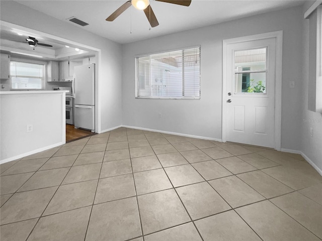 unfurnished living room with ceiling fan, light wood-type flooring, and plenty of natural light