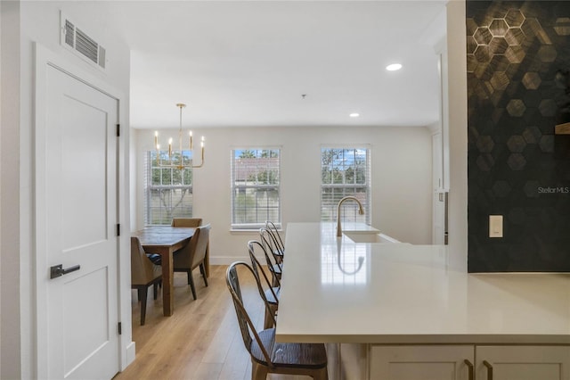 dining room featuring light wood-type flooring and a chandelier