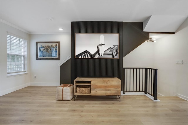 living area with light hardwood / wood-style floors and crown molding