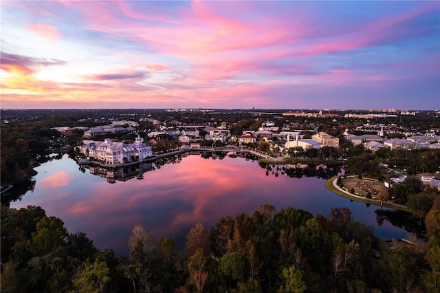 aerial view at dusk featuring a water view