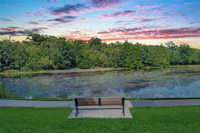 view of property's community with a lawn and a water view