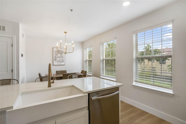 kitchen featuring hanging light fixtures, light hardwood / wood-style floors, dishwasher, sink, and a notable chandelier