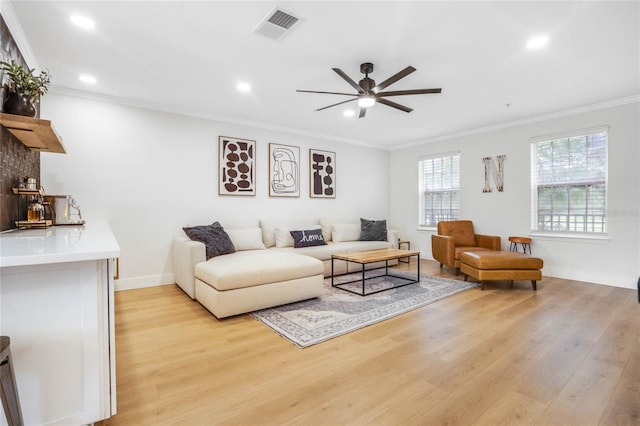 living room with light hardwood / wood-style flooring, ceiling fan, and ornamental molding