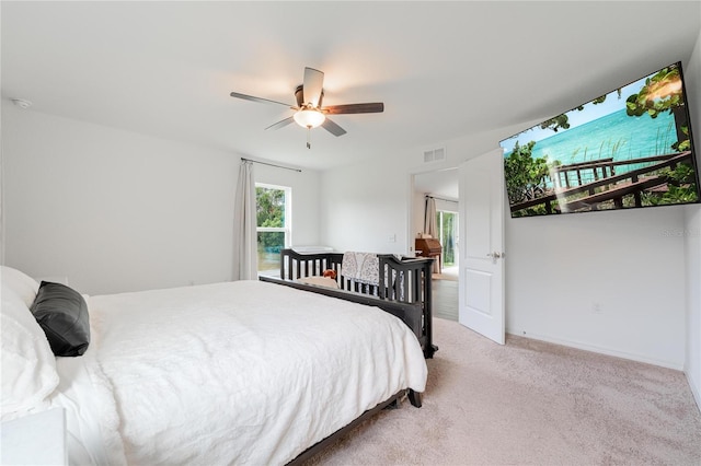 bedroom with ceiling fan and light carpet