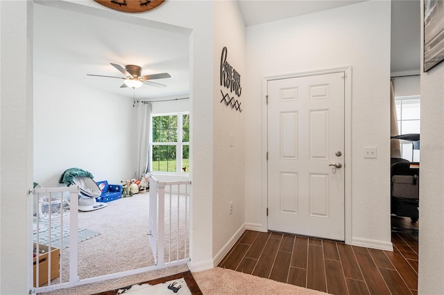 carpeted foyer entrance featuring ceiling fan