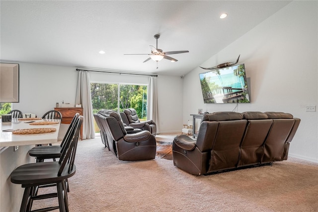 living room featuring ceiling fan, vaulted ceiling, and light colored carpet