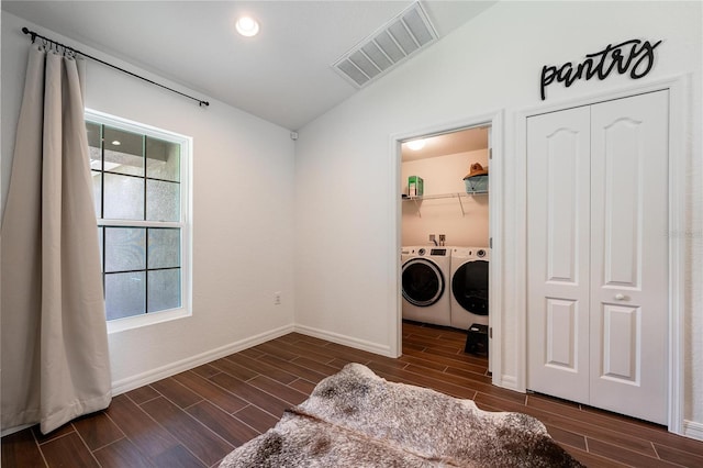 washroom featuring dark hardwood / wood-style floors, washer and clothes dryer, and a healthy amount of sunlight