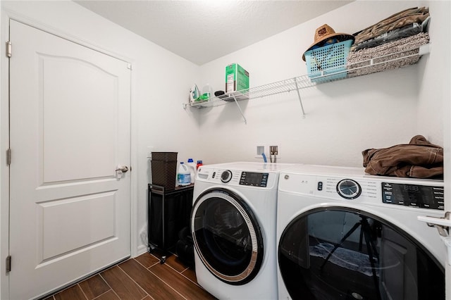 clothes washing area featuring dark wood-type flooring and washer and clothes dryer