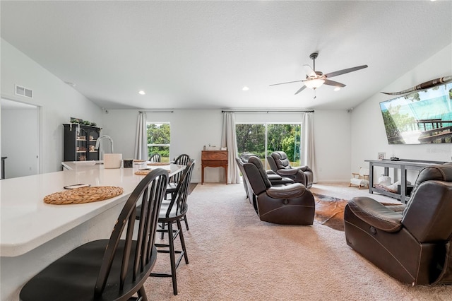 living room featuring ceiling fan, plenty of natural light, light colored carpet, and lofted ceiling