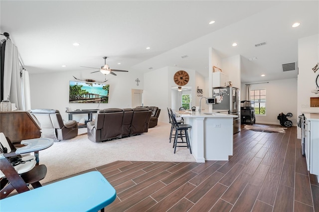 carpeted living room with a wealth of natural light and ceiling fan