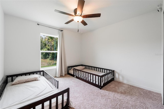 carpeted bedroom with multiple windows and ceiling fan