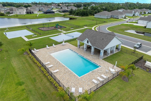 view of swimming pool with a patio, a yard, a playground, and a water view