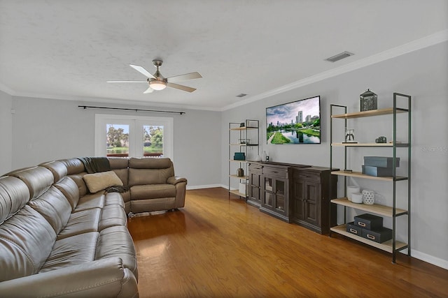 living room featuring baseboards, visible vents, wood finished floors, and ornamental molding