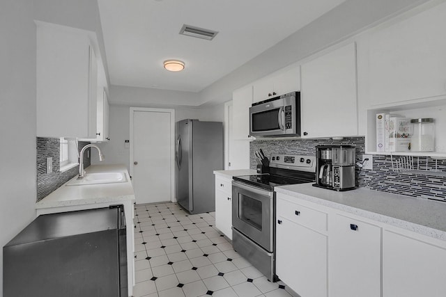 kitchen featuring a sink, visible vents, white cabinetry, light countertops, and appliances with stainless steel finishes