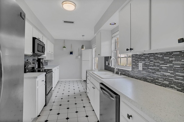 kitchen with light countertops, visible vents, appliances with stainless steel finishes, white cabinetry, and a sink