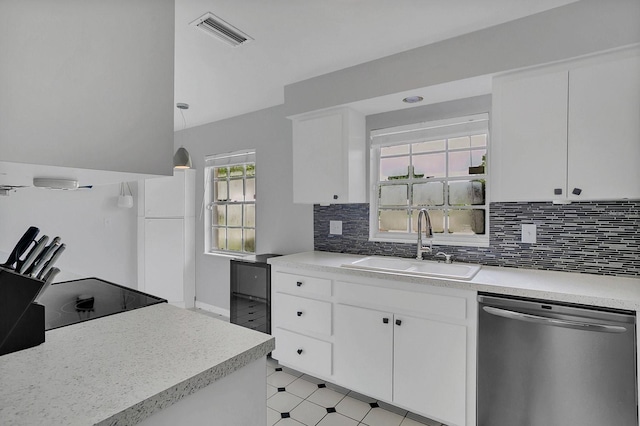 kitchen with light floors, visible vents, freestanding refrigerator, a sink, and dishwasher