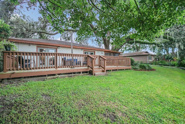 rear view of property with a deck and a lawn