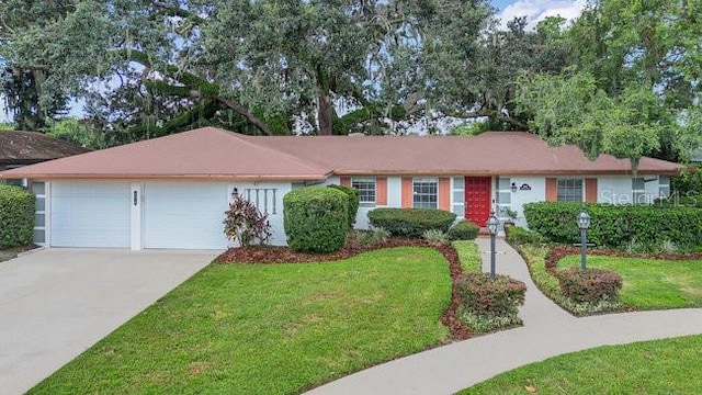 ranch-style home with an attached garage, driveway, and a front yard