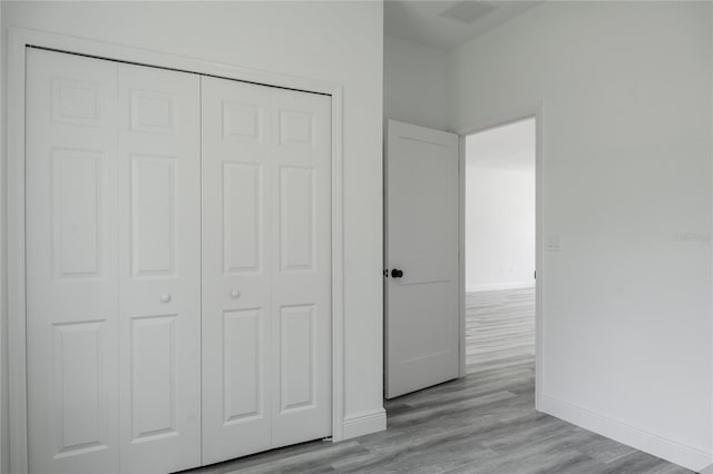 unfurnished bedroom featuring light hardwood / wood-style floors and a closet