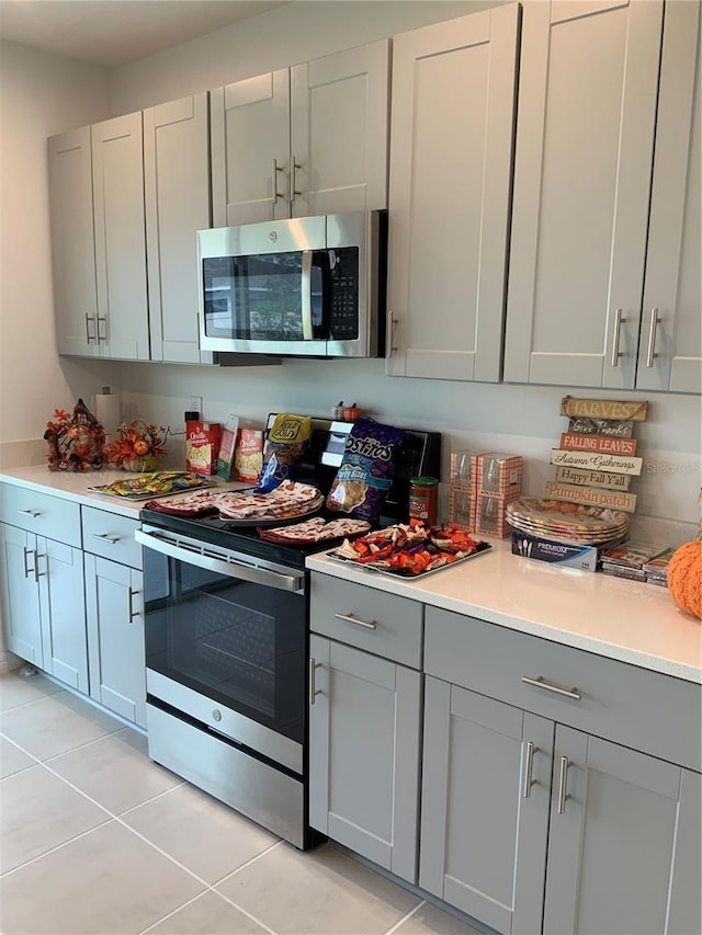 5639 Costa Blanca Way, Davenport, FL 33897 - kitchen with appliances with stainless steel finishes, gray cabinets, light tile patterned flooring, and light countertops
